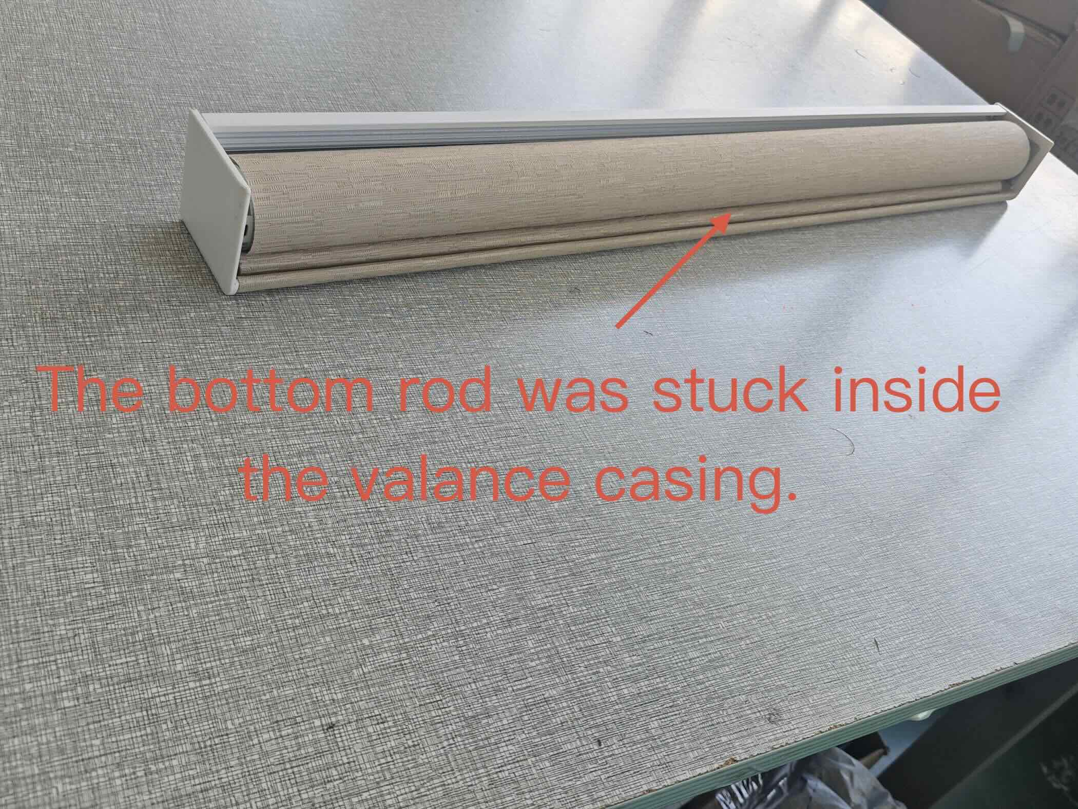 Motorized roller shade bottom rod stuck inside the aluminum valance casing